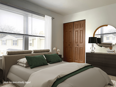A bedroom with a large bed and a wooden door.
