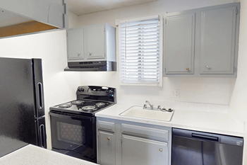 A kitchen with a black refrigerator and stove.