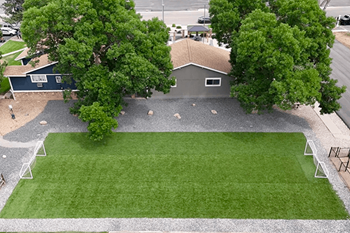 A house with a grey roof and a green lawn.
