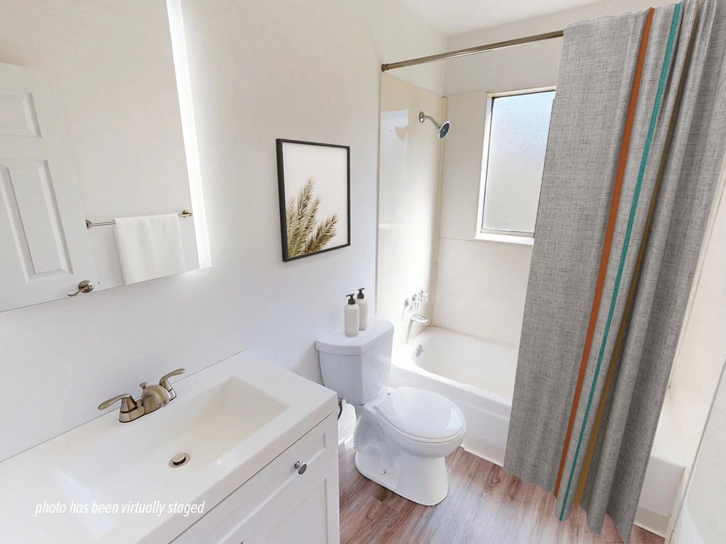 A white bathroom with a white toilet, sink, and shower.