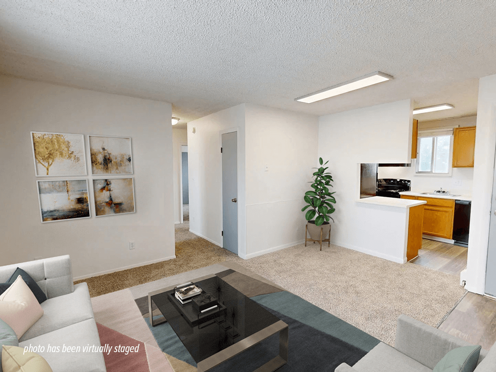 A living room with a couch, coffee table, and pictures on the wall.