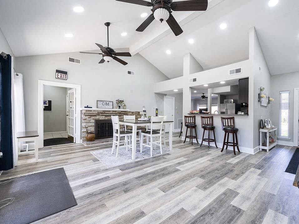 a living room with a kitchen and a ceiling fan