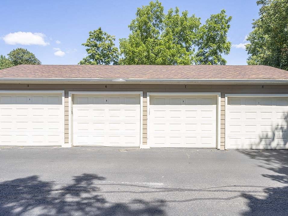 a white garage with a brick roof and white doors