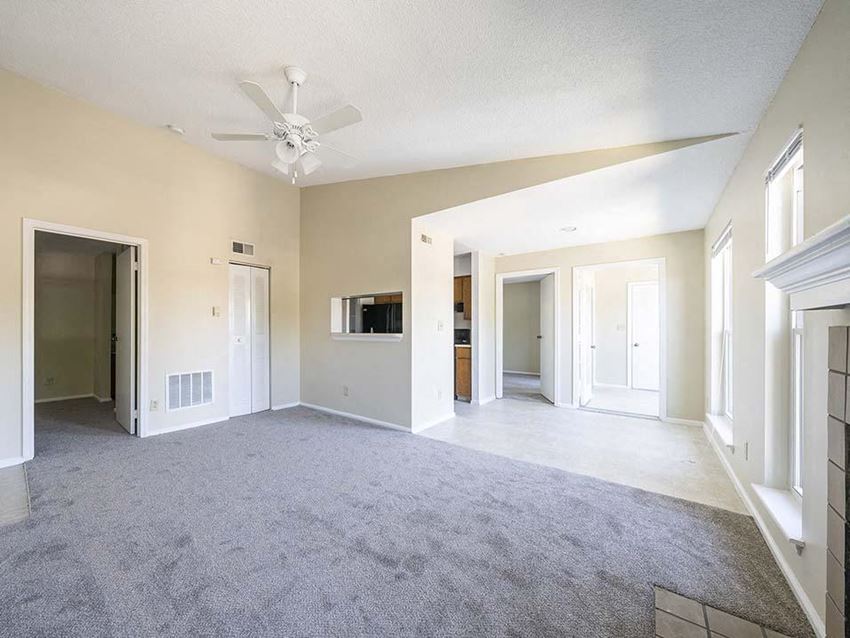 an empty living room with a ceiling fan