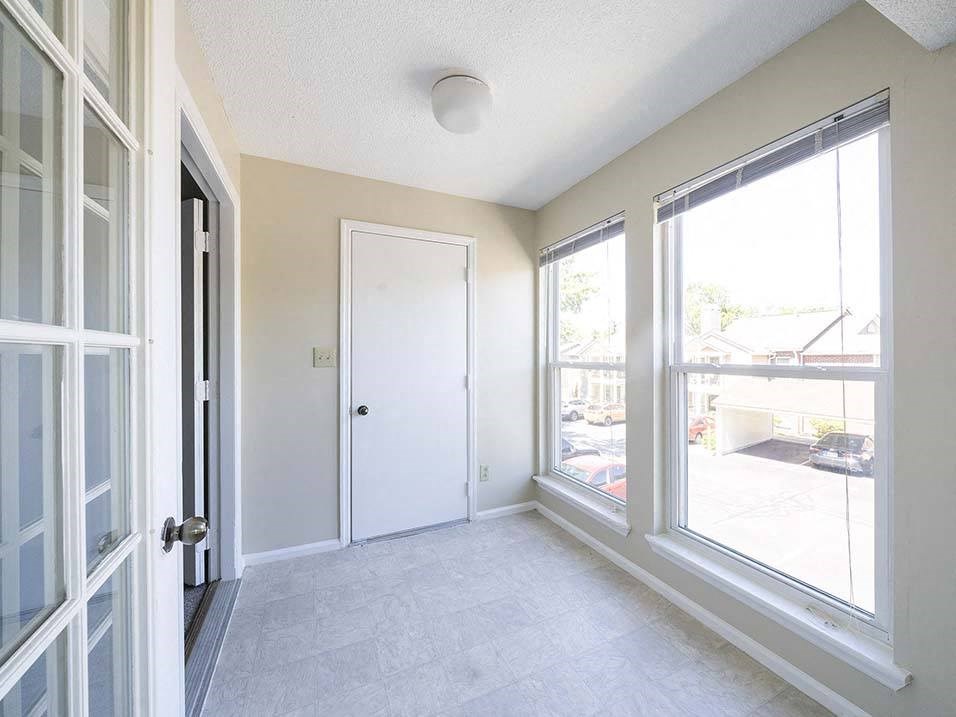 an empty room with large windows and a door