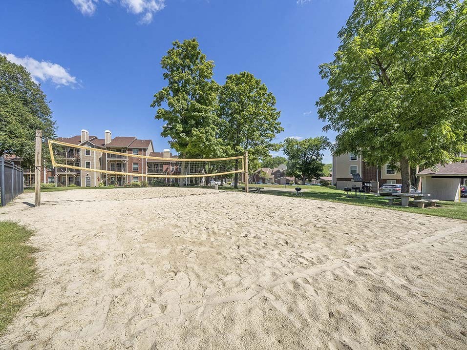 a sand volleyball court with a building in the background
