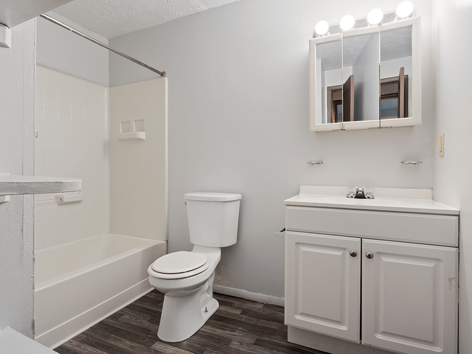 apartment bathroom with a toilet sink and shower