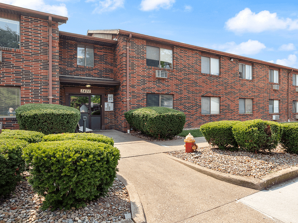 a brick building with bushes