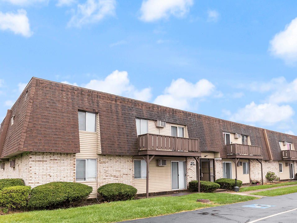 an apartment building with tan bricks and brown roofs