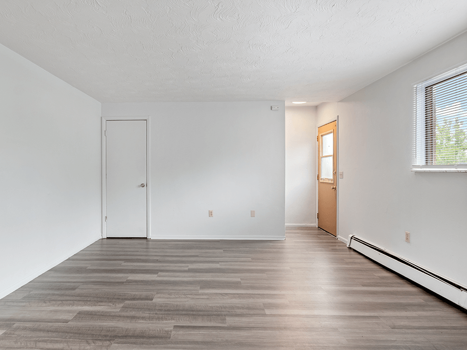 apartment living room with white walls and wood style floors