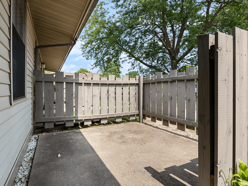 a white fence on the side of a house with a building