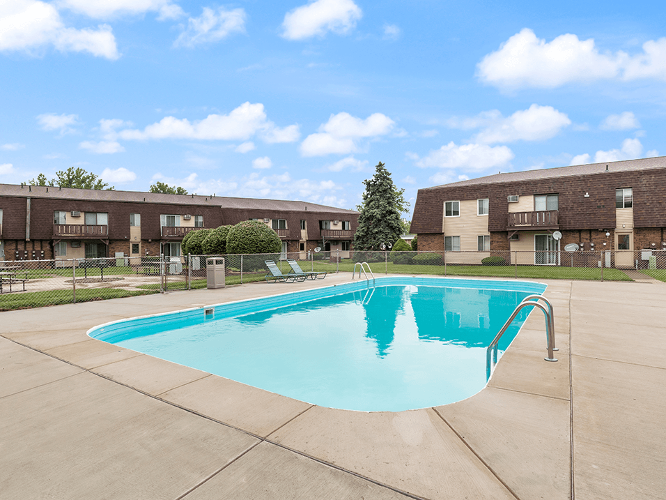a swimming pool in front of an apartment building