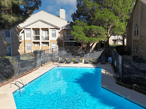 A swimming pool in a backyard surrounded by a fence.