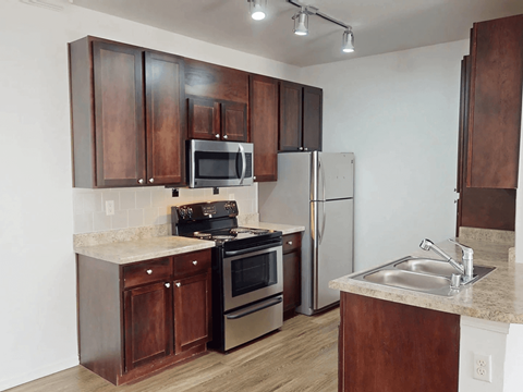 A kitchen with brown cabinets and stainless steel appliances.