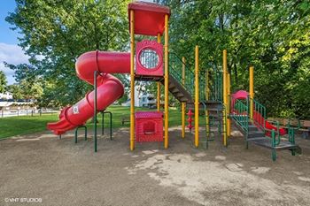a playground with a slide and other toys in a park