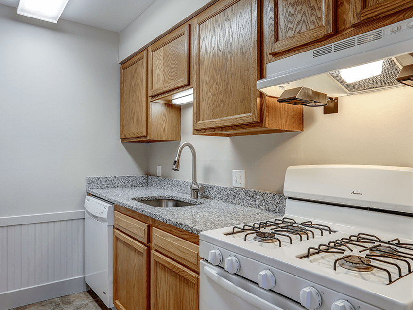 a kitchen with wood cabinets and white appliances - Photo Gallery