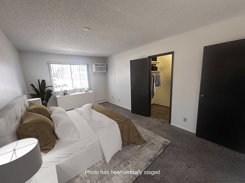 A living room with a white couch and a brown pillow.