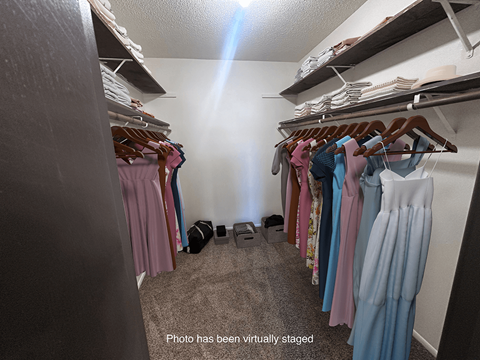 A closet full of clothes and a sign on the floor.