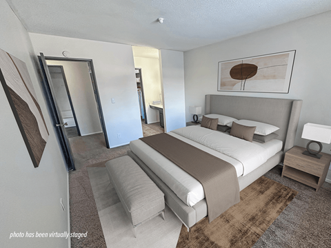 A bedroom with a large bed and a mirror on the wall.