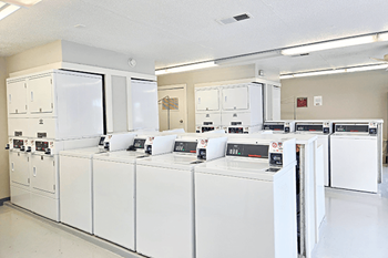 A row of white appliances are lined up in a room.