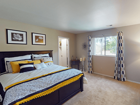 A bedroom with a large bed and two picture frames on the wall.