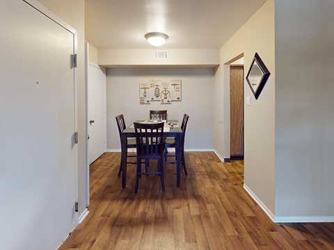A dining room with a wooden table and chairs.