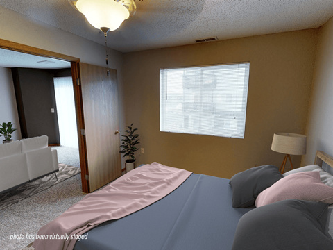 A bedroom with a bed, a chair, and a lamp.
