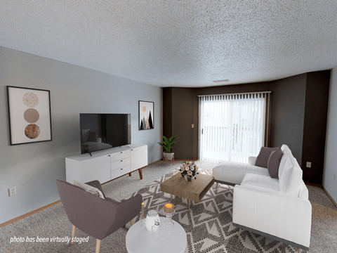A living room with a white couch, a brown chair, a white cabinet, a television, a plant, and a rug.