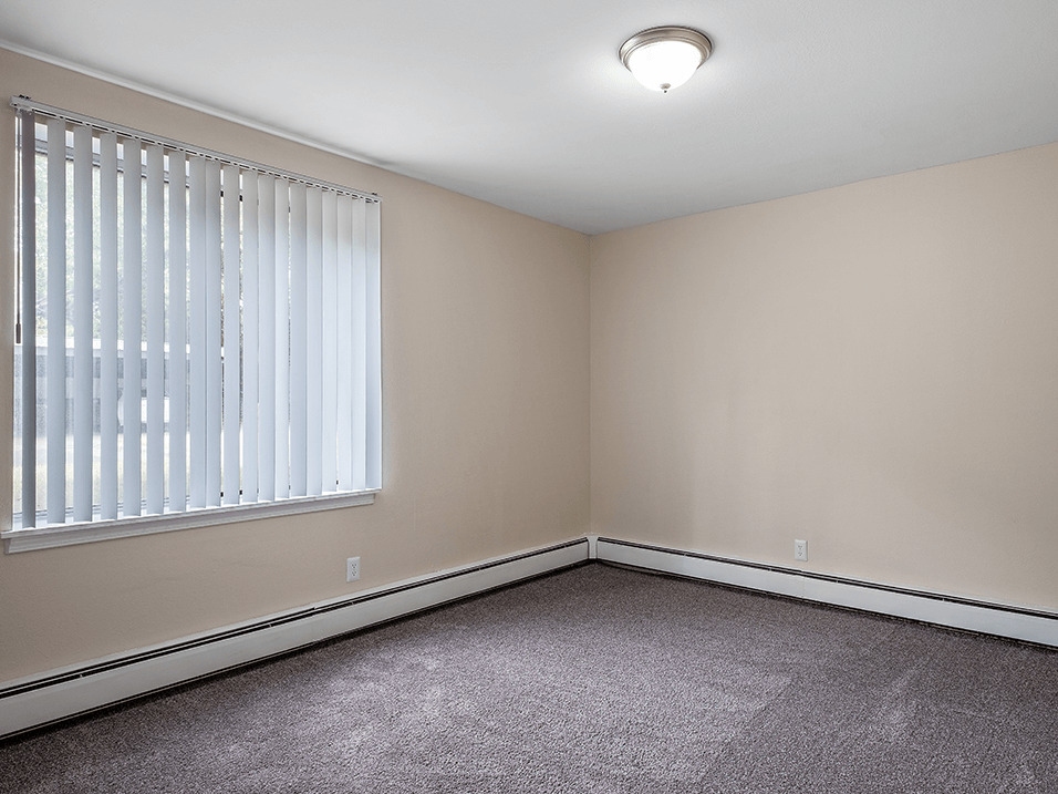 an empty bedroom with a large window