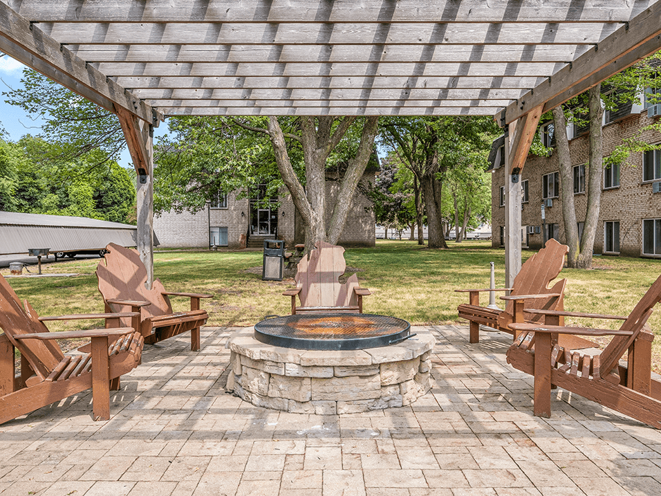 a patio with a fire pit and a pergola