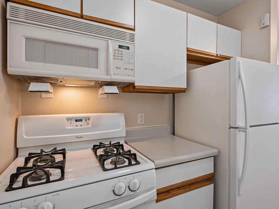 a kitchen with a stove refrigerator and microwave