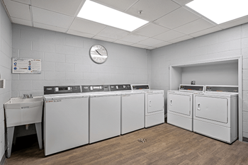 a large laundry room with four washers and two dryers