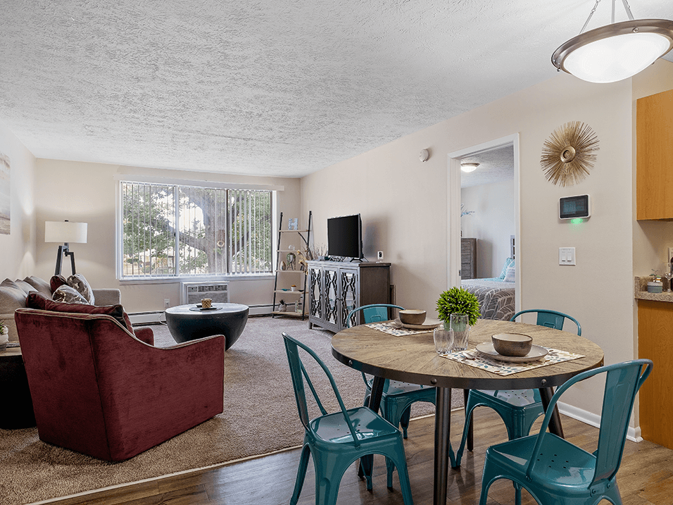 a living room with a round table and chairs and a couch and chair in front of a