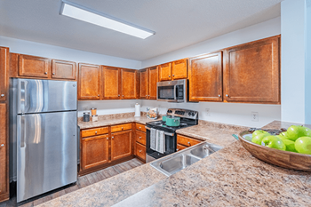 A kitchen with wooden cabinets and granite countertops.