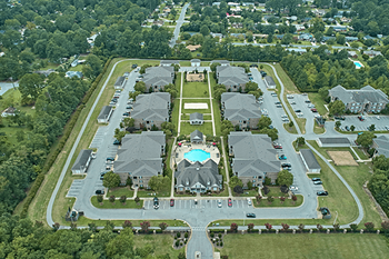 A bird's eye view of a residential area with houses and a swimming pool.