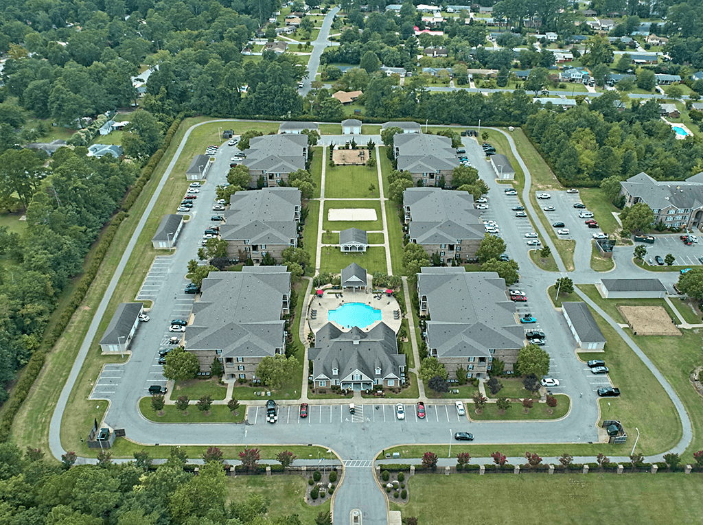 A bird's eye view of a residential area with houses and a swimming pool.