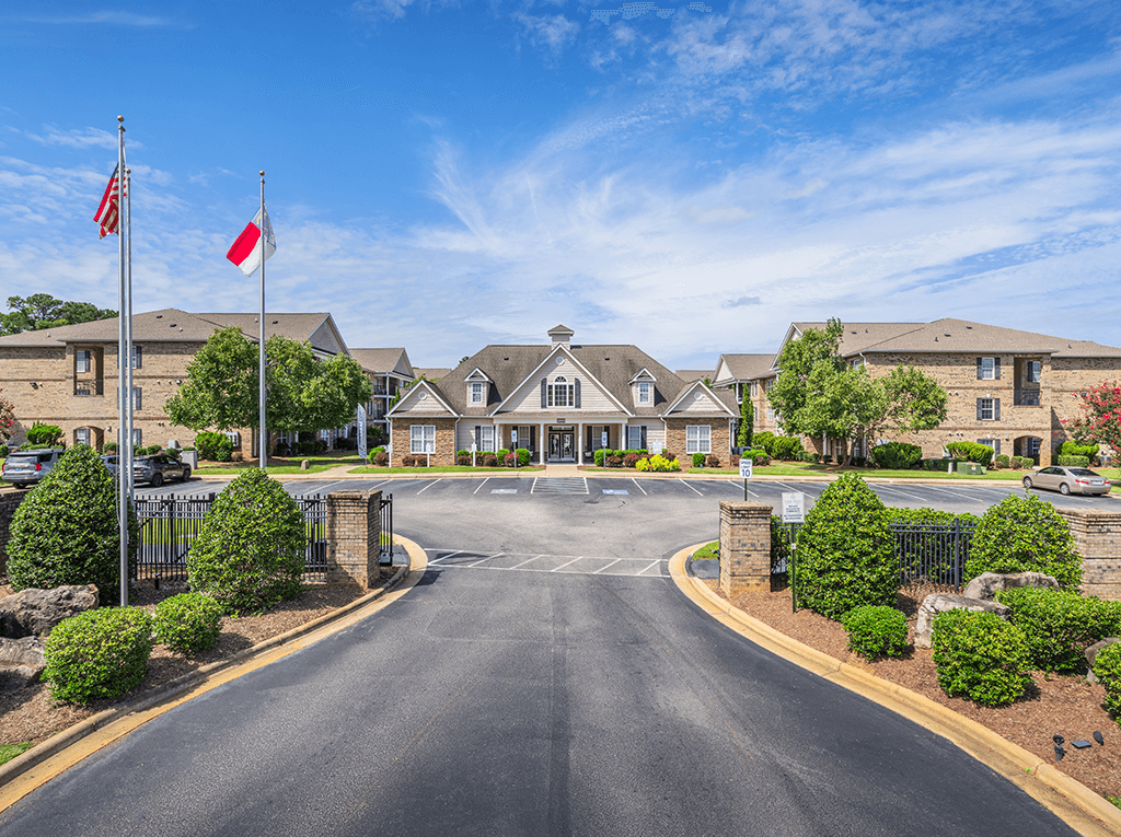 A road leading to a building with flags on either side.