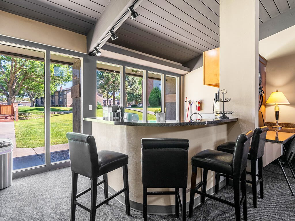A bar area with four black chairs and a counter.