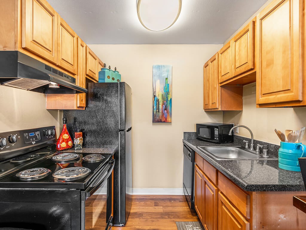 A kitchen with wooden cabinets and a black stove.