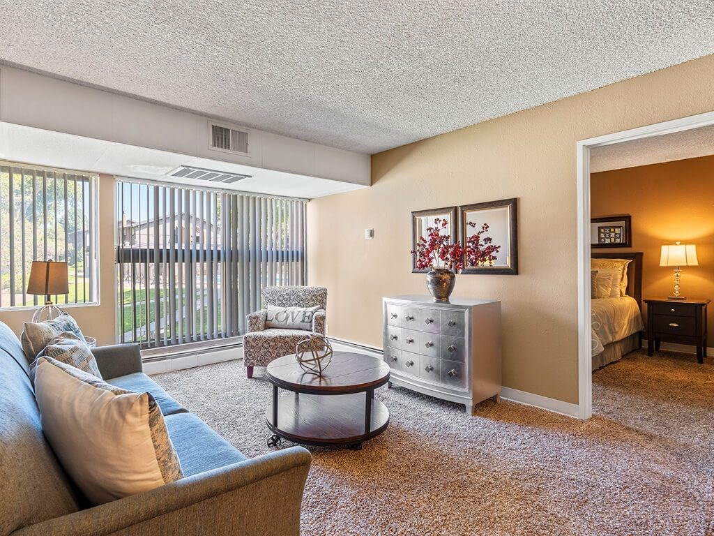 A living room with a grey couch and a white dresser.