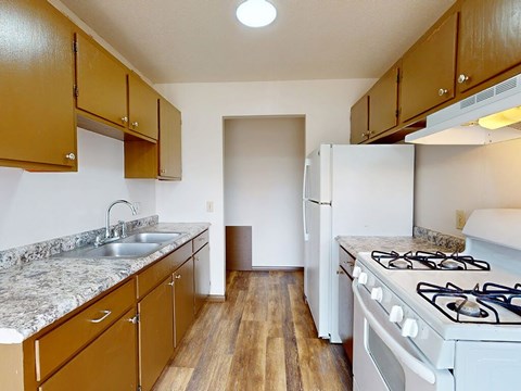 A kitchen with a white stove and brown cabinets.