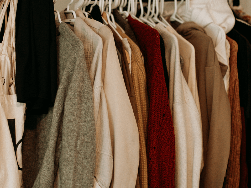 a photo of a closet full of coats and sweaters