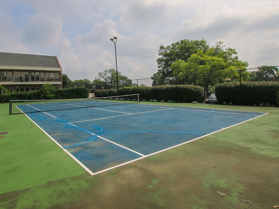 a blue tennis court at apartment community