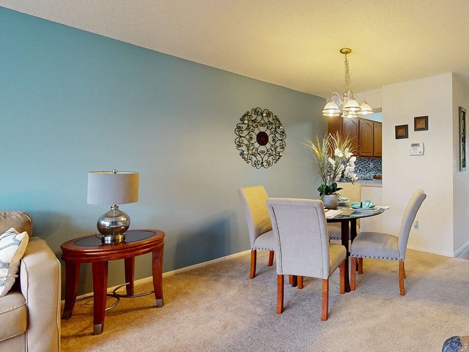 a living room and dining room with a table and chairs