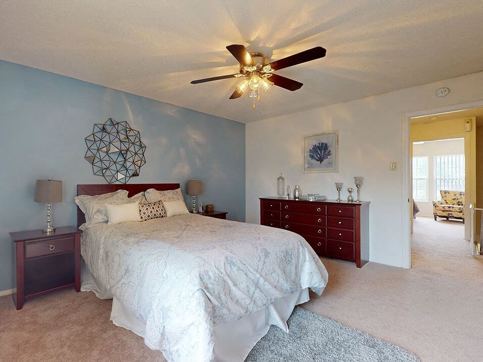 a bedroom with a bed and a ceiling fan