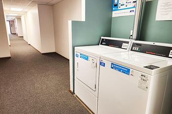 A white washing machine is in a hallway.