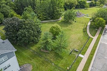 an aerial view of a park with trees and a sidewalk