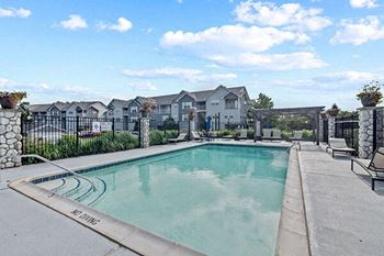 a swimming pool with chairs and a fence around it