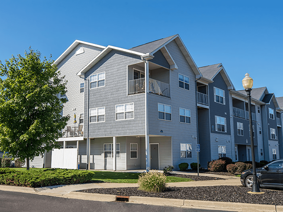 an apartment building with a car parked in front of it