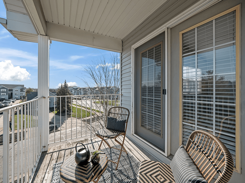 a patio with chairs and a table on a balcony